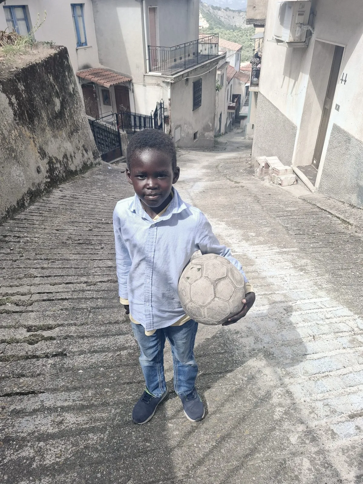 Des enfants jouent au football dans une ruelle de Camini