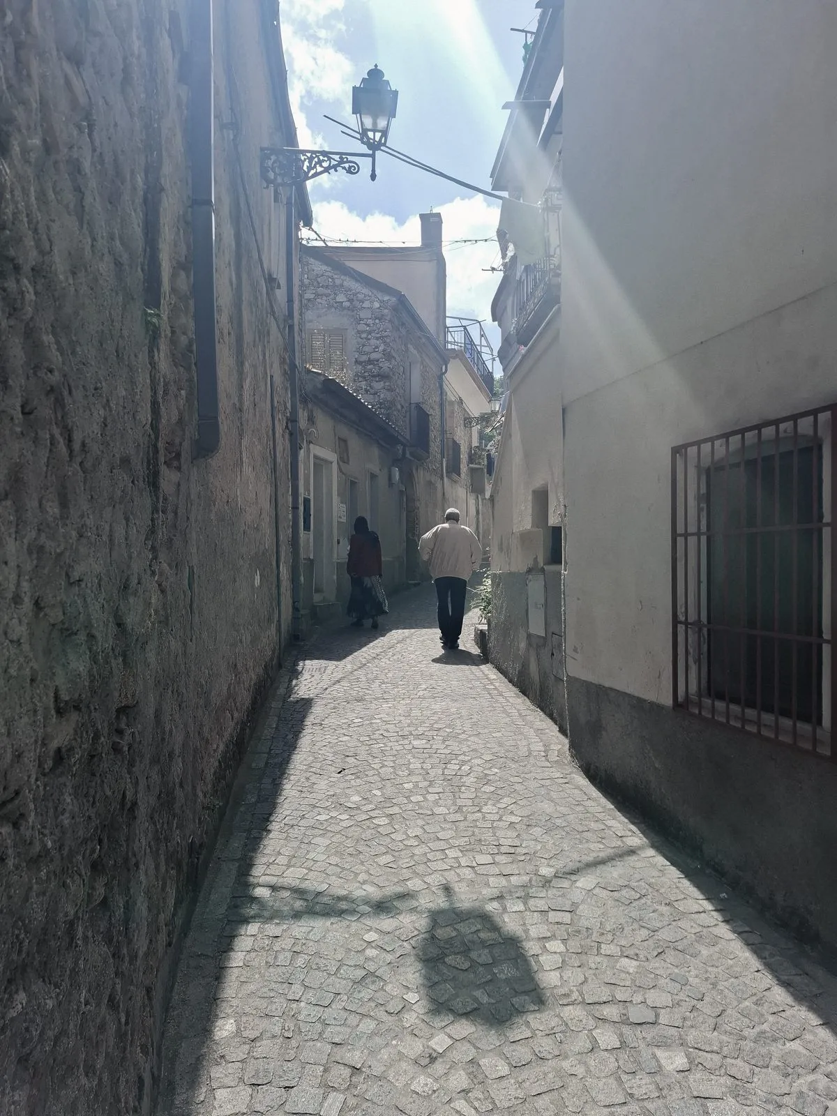 Ruelle de Camini à contre-jour, un homme et une femme s'éloignent